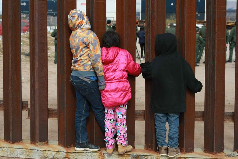 Un grupo de niños observan a agentes de migración de Estados Unidos que realizan practicas. (Agencia EFE)