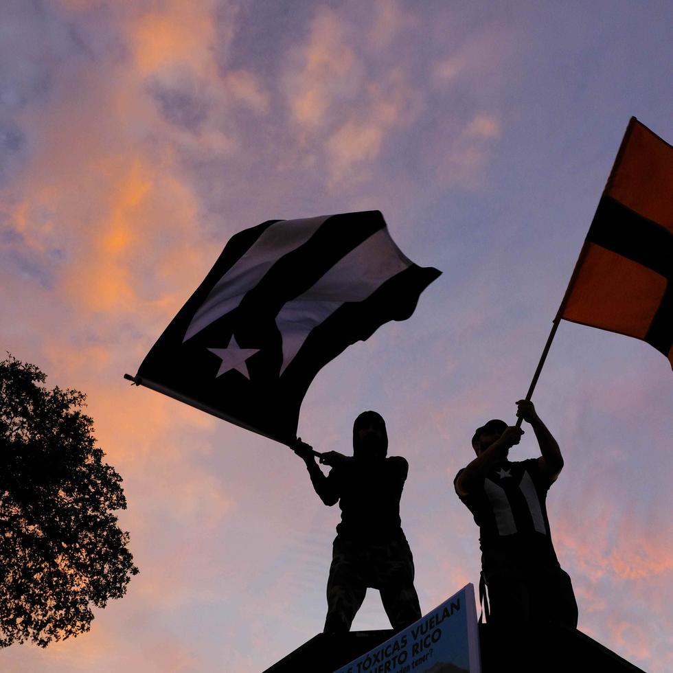 Manifestantes ondeaban las banderas de Puerto Rico y Peñuelas durante la protesta.