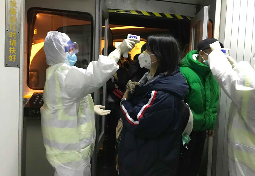 Funcionarios de salud de China inspeccionan a pasantes en la ciudad de Wuhan. (AP)