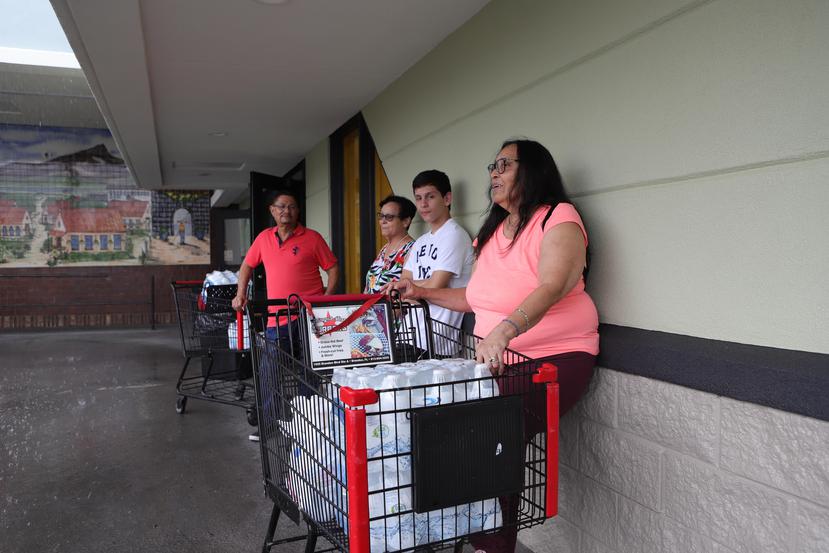 Teresa López (segunda desde la izquierda) huyó de la isla para esquivar el huracán que ahora se acerca a Florida. Ayer, compró suministros  y agua en un supermercado de Kissimmee.