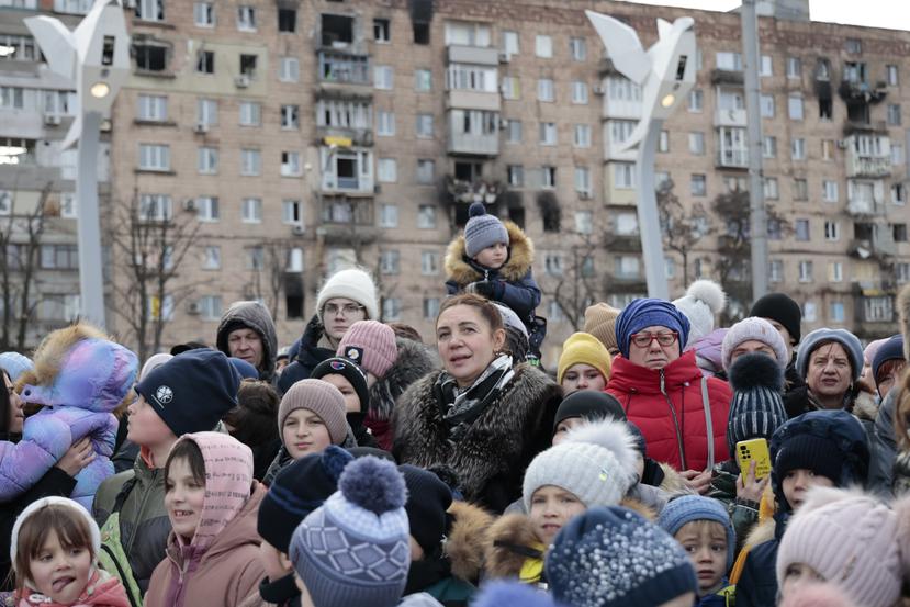 Ciudadanos locales observan una actuación cerca de un árbol de Navidad decorado para las festividades de Navidad ortodoxa y Año Nuevo en Mariupol, en la región de Donetsk controlada por Rusia, en el este de Ucrania.