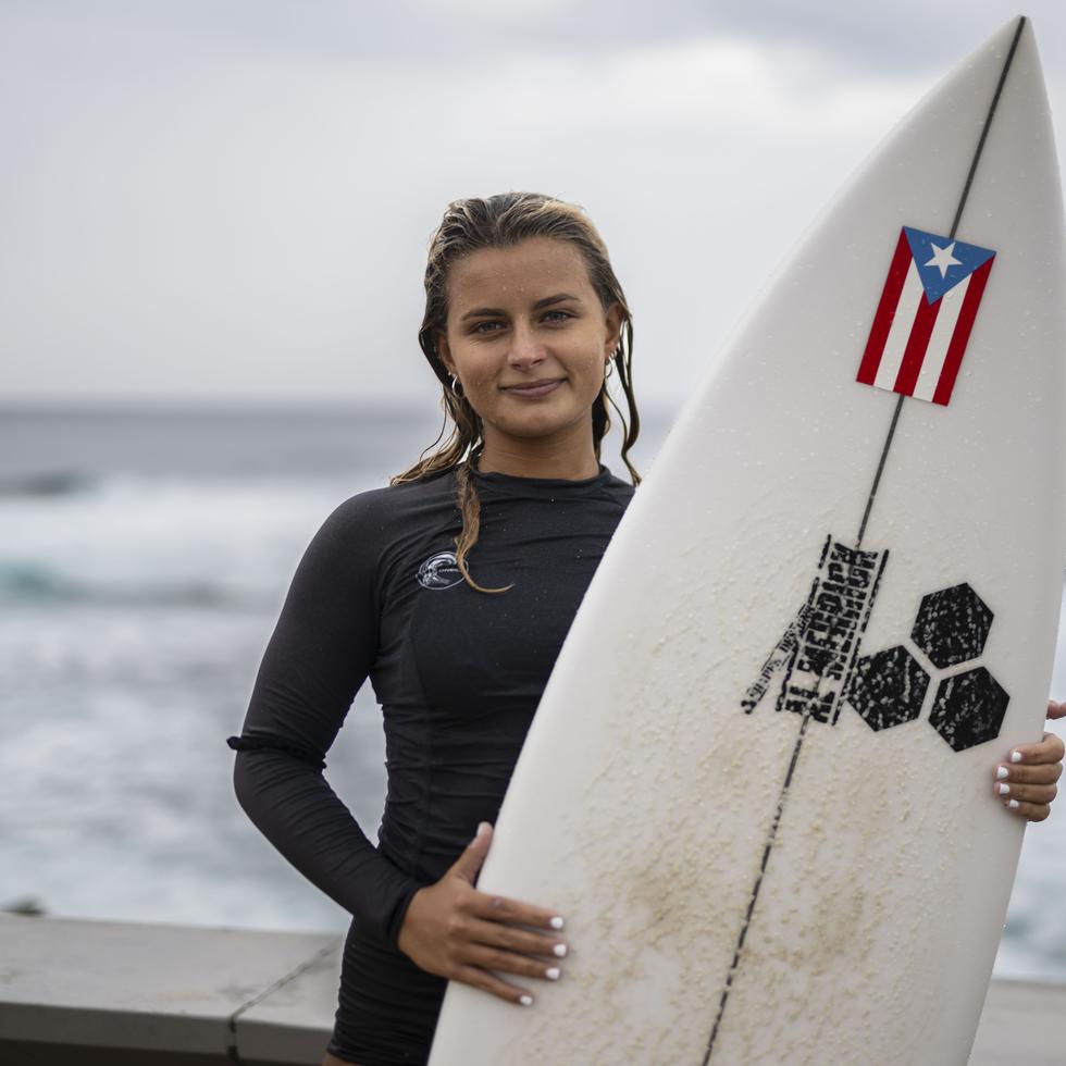 Mia Calderón posa con su tabla de surf desde La Marginal de Arecibo, escenario que acogerá el Mundial de Surfing.