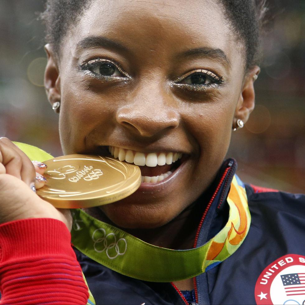 La estadounidense Simone Biles muerde su medalla de oro tras ganar el concurso combinado de la gimnasia artística en los Juegos Olímpicos de Río de 2016.