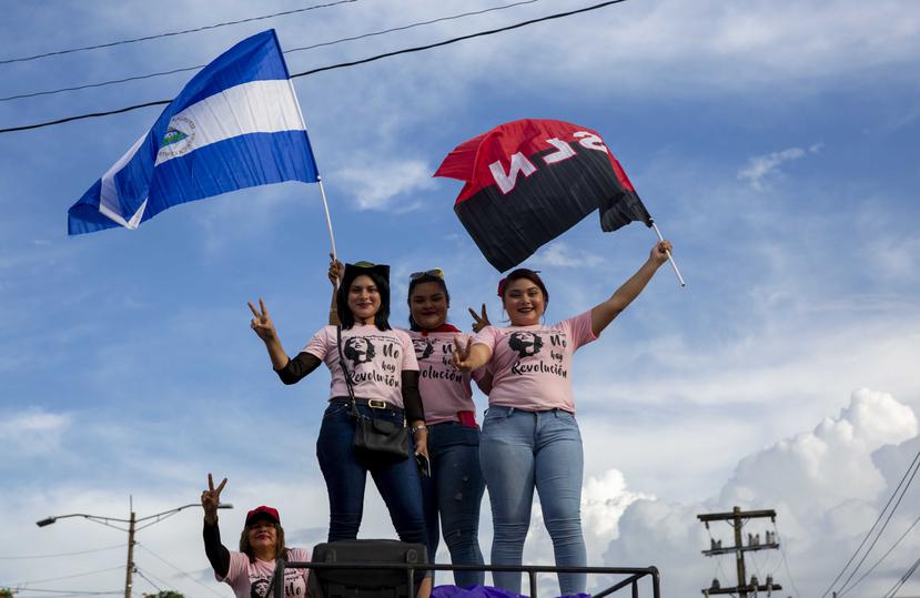 Jóvenes con una bandera de Nicaragua (i), y una del partido Frente Sandinista de Liberación Nacional. (EFE / Jorge Torres)