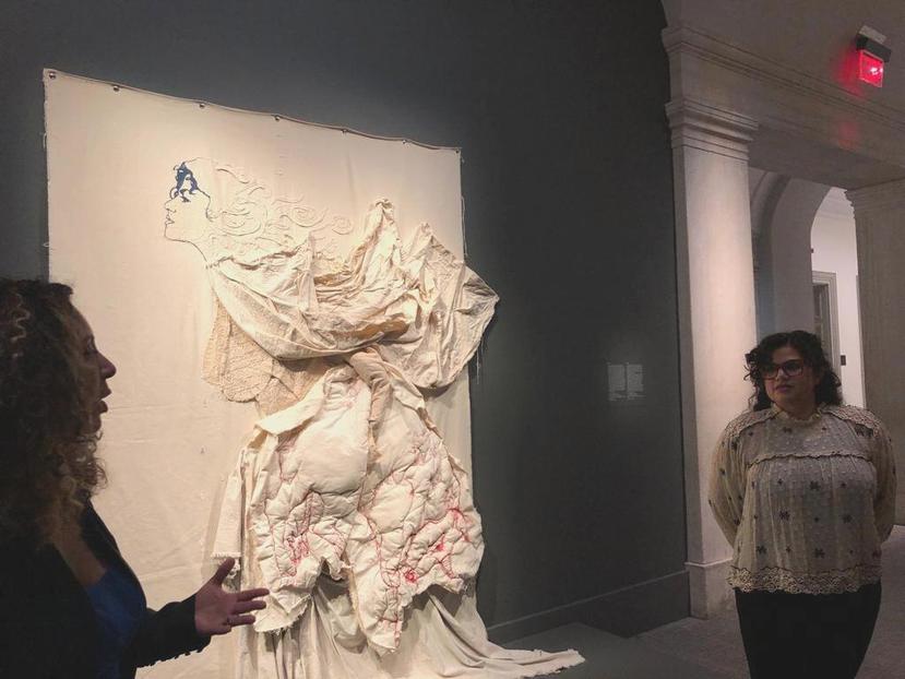 Taína Caragol, curadora de la exposición, y la artista Elsa María Meléndez, derecha, con su obra “Leche", en la Galería de Retratos de Washington D.C.