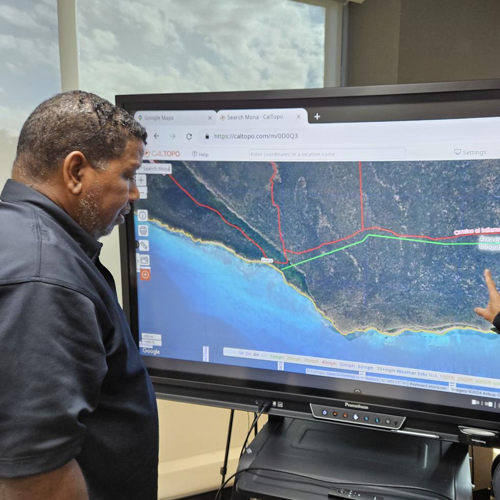 El comisionado de NMEAD, Nino Correa (izq.) y el coordinador de búsqueda y rescate, Ángel "Tito" Vázquez, observan un mapa relacionado a la búsqueda del cazador Jorge Cordero Adorno en Isla de Mona.