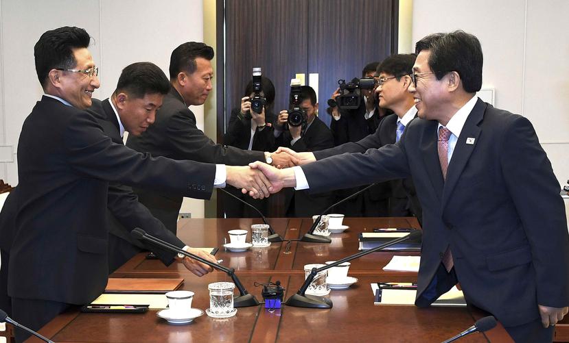 El jefe de la delegación surcoreana, Jeon Choong-ryul, estrecha la manos de su homólogo norcoreano, Won Kil U, durante una reunión en la localidad de Panmunjom, en la zona desmilitarizada. (AP)
