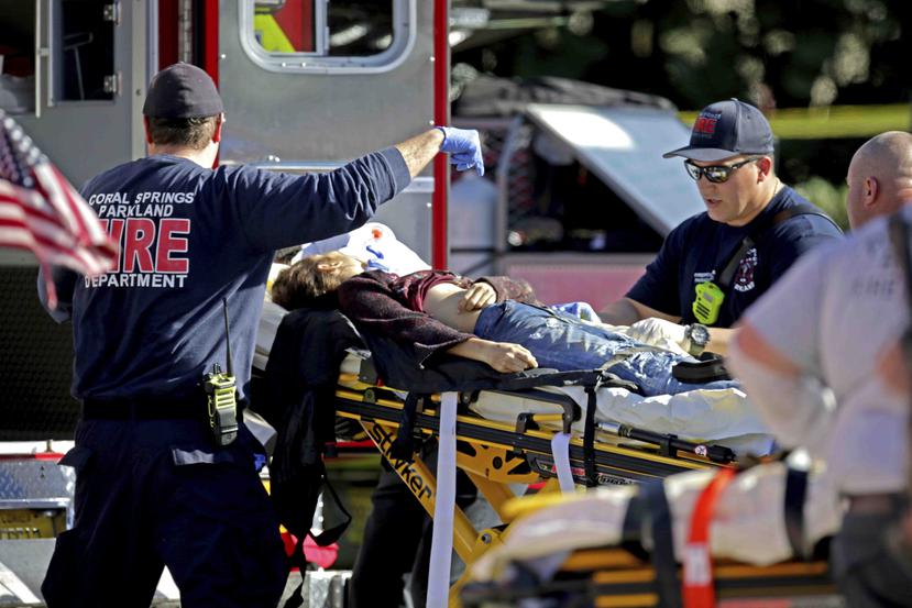 Personal sanitario asiste a una víctima de un tiroteo en la escuela secundaria Marjory Stoneman Douglas en Parkland, Florida. (AP)