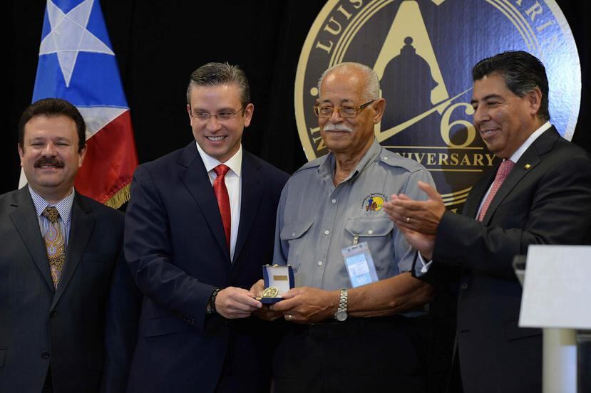 El gobernador, Alejandro García Padilla, le entrega reconocimiento a Sixto Negrón, el maletero más antiguo en el aeropuerto.