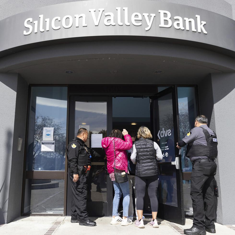 Guardias de seguridad permiten a personas ingresar en la sede del Silicon Valley Bank en Santa Clara, California, el lunes 13 de marzo de 2023. (AP Foto/ Benjamin Fanjoy)