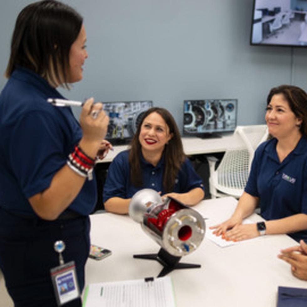 La profesora del RUM Sheilla Torres, al centro mientras conversa con dos estudiantes, estuvo en el proceso desde identificar el espacio hasta la inauguración del TurboLab auspiciado por la compañía de diseño y creación de motores para aeronaves Pratt & Whitney.