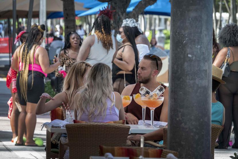 Varias personas compartiendo al aire libre en Miami Beach. (EFE)