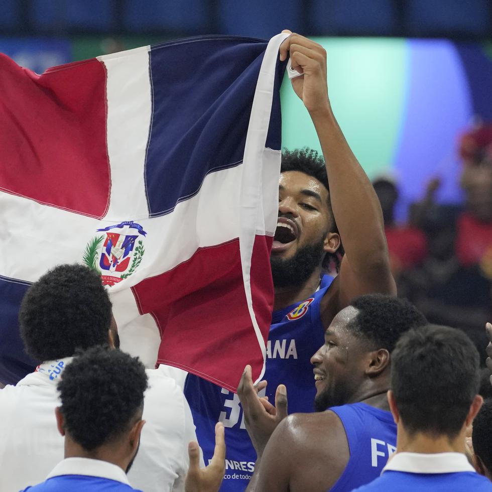 Karl-Anthony Towns (32) levanta una bandera de República Dominicana tras la victoria sobre Angola.