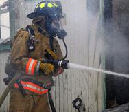 Foto de archivo de un bombero mientras realizaba labores de extinción de incendios en residencias.