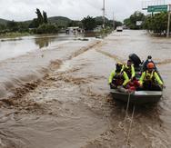 Rescatistas utilizan un bote para encontrar personas desparecidas en La Lima, Honduras.