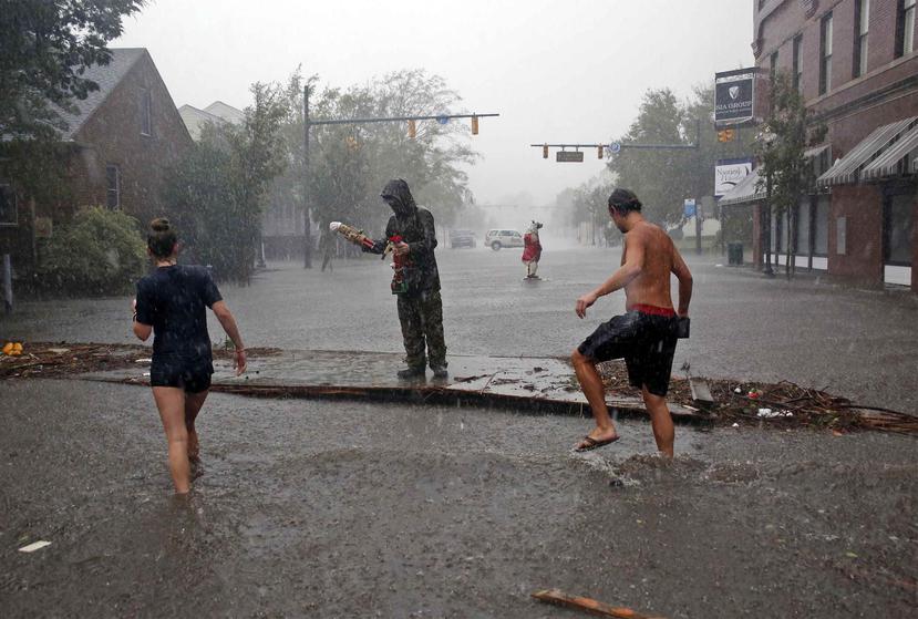 Varias personas inspeccionan los daños causados tras el paso del huracán Florence en la calle Front de New Bern, Carolina del Norte, el viernes 14 de septiembre de 2018. (AP)