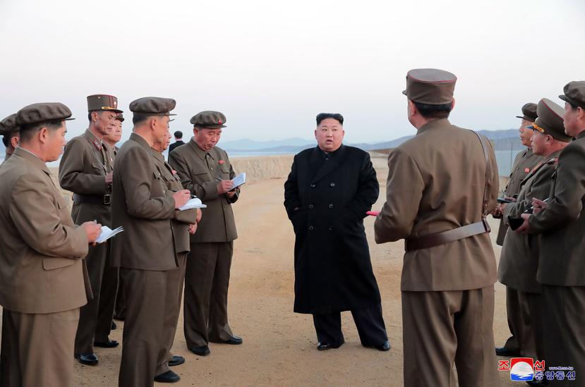 En esta foto sin fecha difundida el viernes 16 de noviembre de 2018 por el gobierno de Corea del Norte, el gobernante de ese país, Kim Jong Un, al centro, escucha a un oficial militar mientras inspecciona la prueba de un arma en la Academia de Ciencia Nac