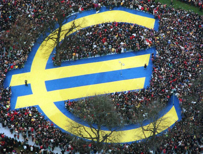 Miles de personas rodean un enorme símbolo del euro en un parque de Fráncfort. (AP)