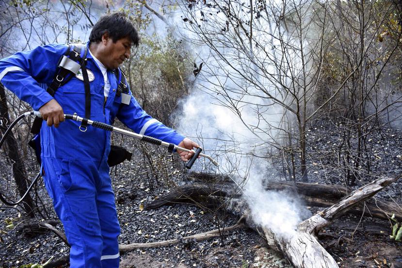 El presidente boliviano Evo Morales rocía agua en un incendio en las afueras de Roboré, Bolivia. (AP)