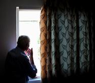 1714622476 - Elderly man indoors in the house looks out the window. Loneliness. Corona virus. Stay at home, stay safe. (Shutterstock)SOLITUDE, LONELINESS, SOLEDAD, AISLAMIENTO, ENVEJECIENTE, ADULTO MAYOR 