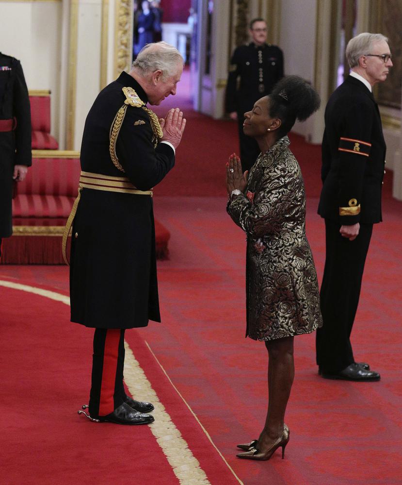 El príncipe Charles saluda a Floella Benjamin sin estrecharle la mano durante la ceremonia de investidura de esta como Dama Comandante del Imperio Británico. (Foto: AP)_