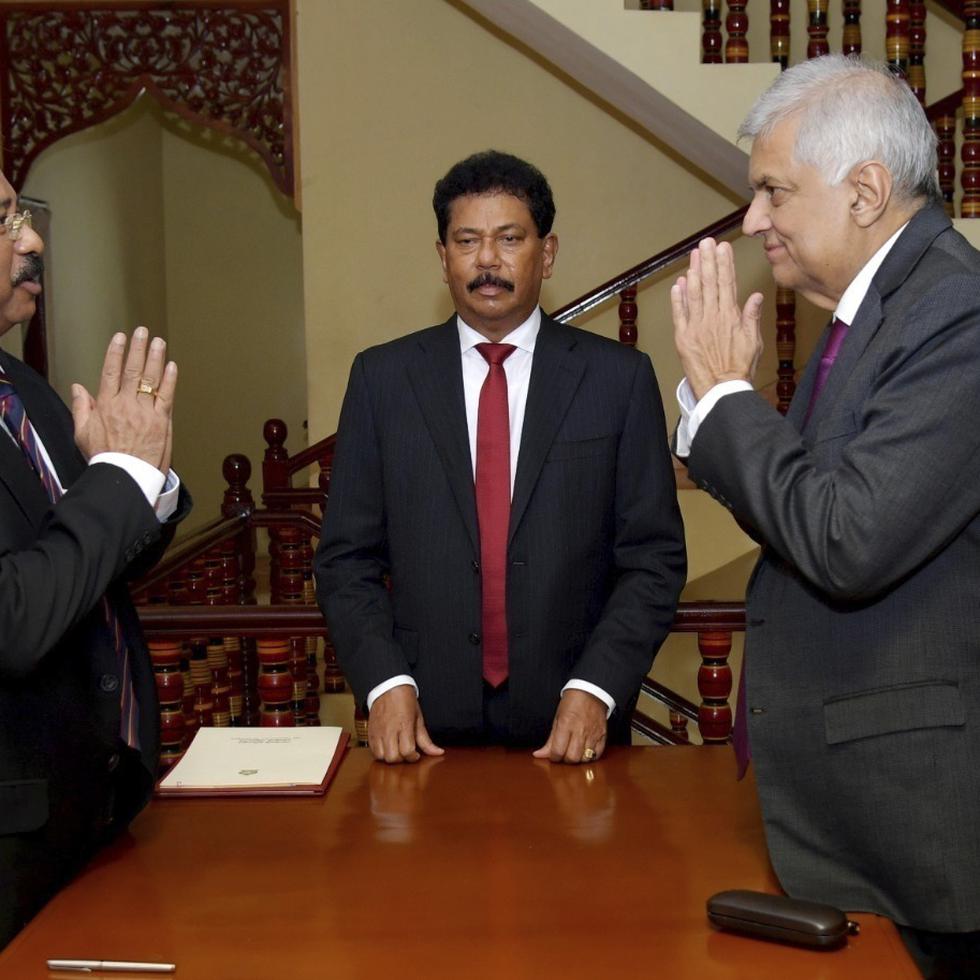 En esta foto distribuida por la presidencia de Sri Lanka, el presidente interino Ranil Wickremesinghe, derecha, saluda al presidente de la Corte Suprema, Jayantha Jayasuriya durante la ceremonia de juramentación en Colombo, Sri Lanka, viernes 15 de julio de 2022.