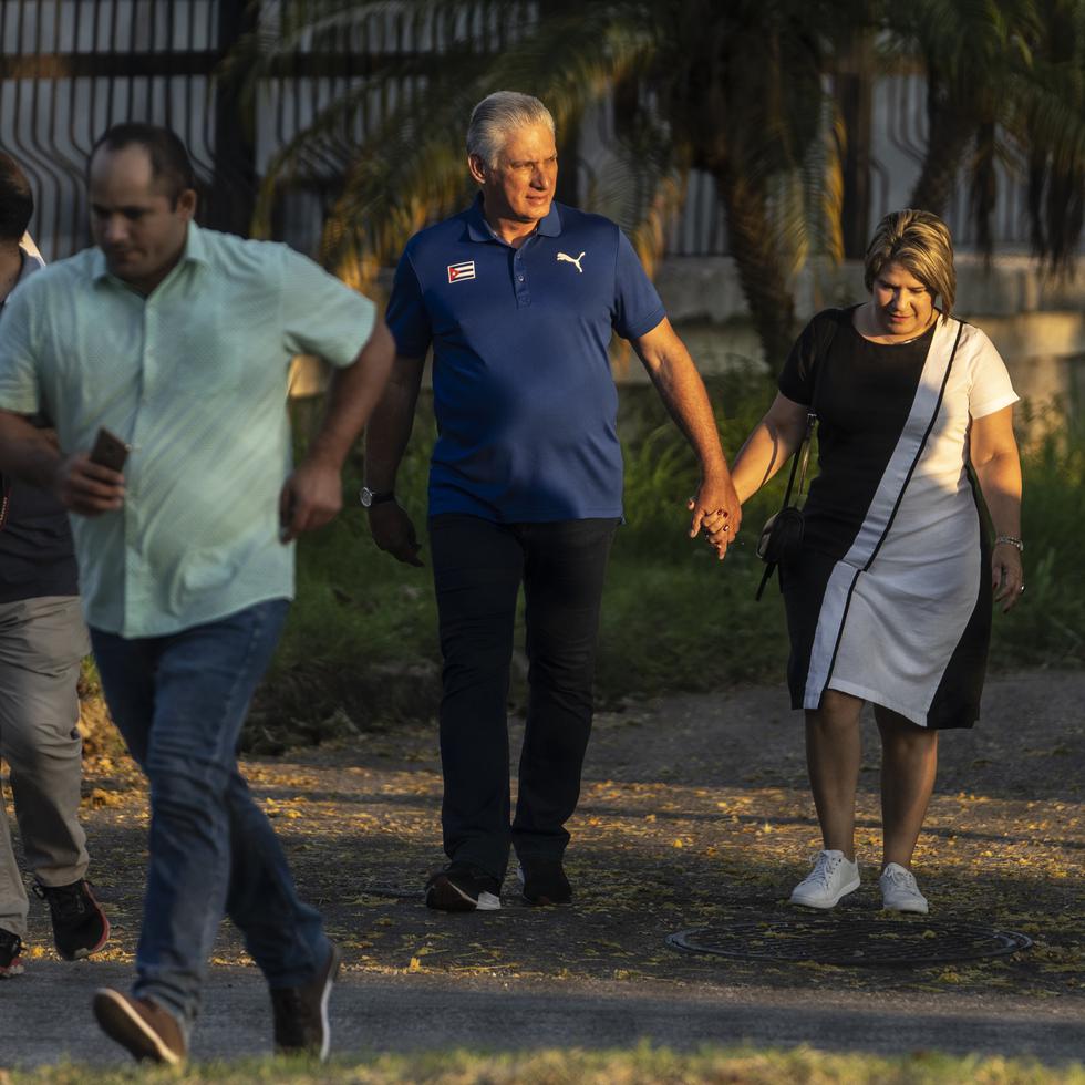 Visto a través de una valla, el presidente de Cuba, Miguel Díaz-Canel, camina con su esposa Lis Cuesta Peraza antes de emitir su voto en un colegio electoral durante el referéndum sobre el nuevo Código de las Familias en La Habana, Cuba.