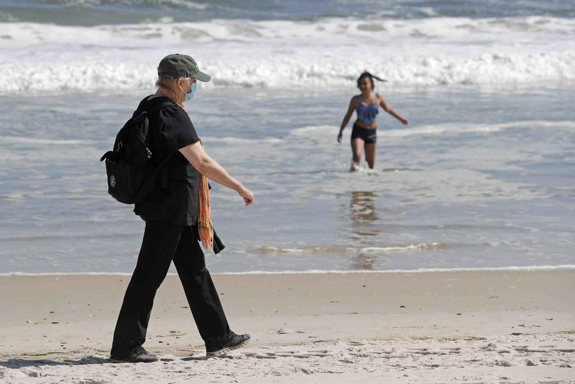 Una mujer camina junto a la orilla en la playa Jones Bach, en Wantagh, Nueva York, el 21 de mayo del 2020. (AP)