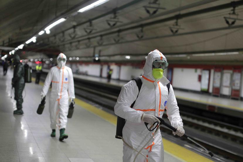 Militares protegidos desinfectan el Metro de Madrid. (AP)