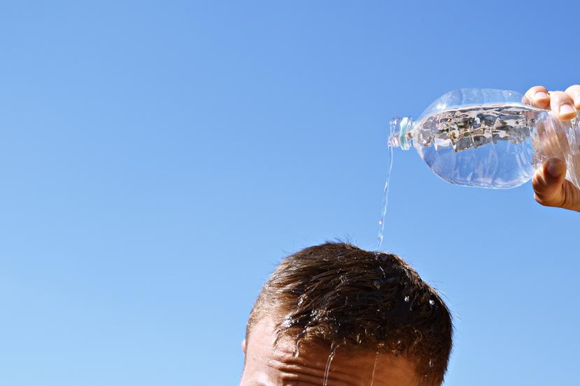 Un hombre se echa agua por encima de la cabeza ante la alta sensación de calor.