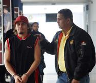 In this photo taken  Sunday, April 18, 2010, Venezuela's former lightweight boxing champion Edwin Valero, left, is escorted by a police officer to a police station in Valencia, some 150 kms, some 93 miles, west of Caracas. Valero committed suicide in his jail cell on early Monday just hours after he was arrested in his wife's killing, police said.  (AP Photo/Edsau Olivares /Notitarde)