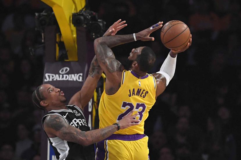 LeBron James, de los Lakers de Los Ángeles, dispara frente a DeMar DeRozan, de los Spurs de San Antonio. (AP)