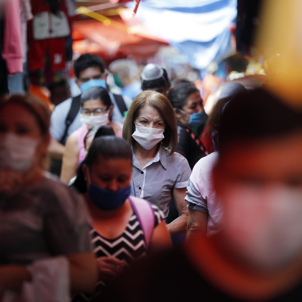 Shoppers, wearing protective face masks as a precaution against the spread of the new coronavirus, fill a local market in Asuncion, Paraguay, Tuesday, May 5, 2020. The government authorized the reopening of some businesses under a plan coined, "intelligent quarantine”. (AP Photo/Jorge Saenz)