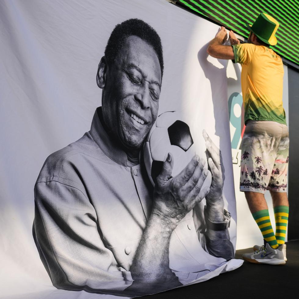 Un aficionado coloca un cartel de apoyo a Pelé en una fiesta de torcedores de Brasil previo al partido contra Corea del Sur.