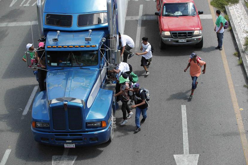 Migrantes hondureños suben a vehículos que se encuentran en el camino para continuar otro tramo del territorio mexicano rumbo a su objetivo principal, Estados Unidos. (EFE)
