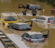 Voluntarios buscan víctimas en automóviles inundados en una carretera en Erftstadt, Alemania.