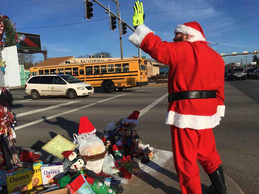 En esta fotografía del 18 de diciembre de 2018, Jimmy Izbinski, vestido con un traje de Santa, saluda a los automovilistas que pasan por una marihuana navideña en Toledo, Ohio. (AP)
