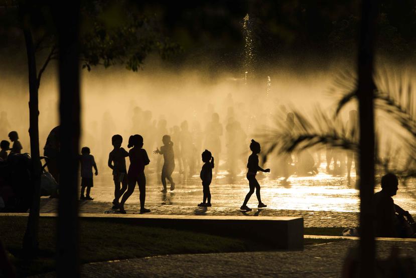 Niños juegan en una fuente en Madrid ante el calor que azota el país.