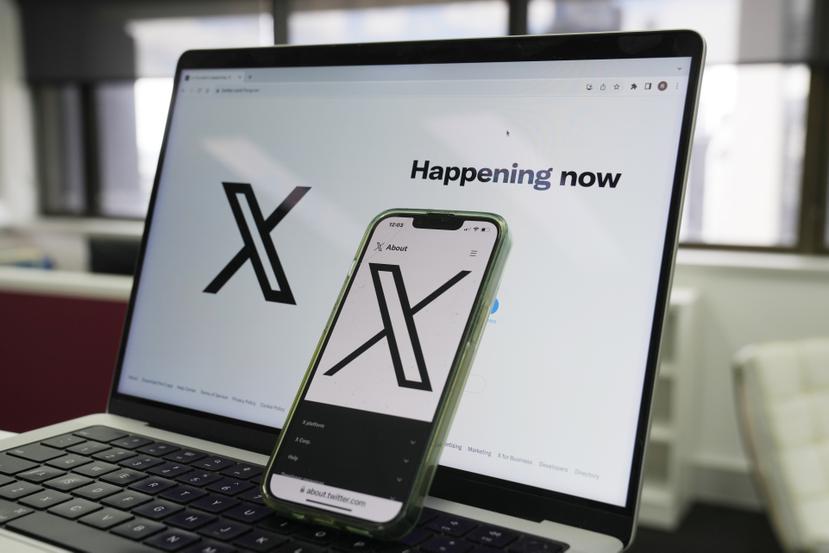 La página de inicio de X se ve en una computadora y un celular en Sydney, el lunes 16 de octubre de 2023. (AP Foto/Rick Rycroft)