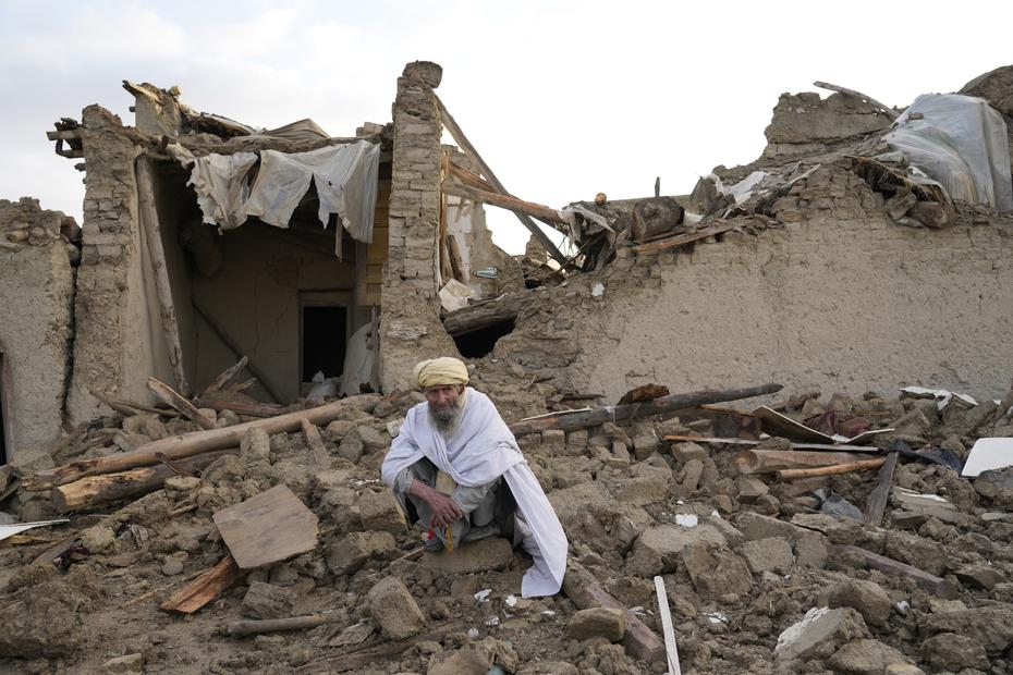 Un afgano se sienta entre las ruinas de su hogar en Gayan.