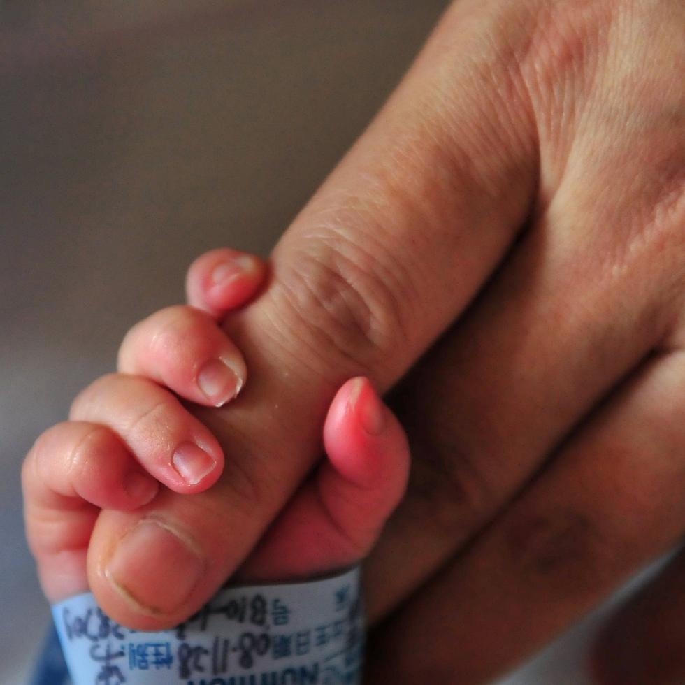 A newborn baby holds onto his mother's finger at a hospital in Beijing on December 1, 2008. The Chinese government has insisted extensive measures have been taken to ensure melamine is no longer in China's dairy supply after admitting that a total of 294,000 children had fallen ill from consuming dairy products tainted with the industrial chemical, normally used to make plastics, after it emerged in September that melamine had been routinely mixed into Chinese milk and dairy products to give  the impression of having a higher protein content. The scandal quickly became a global problem, with Chinese dairy products around the world recalled or banned after they were found to be tainted with the industrial chemical. AFP PHOTO/Frederic J. BROWN