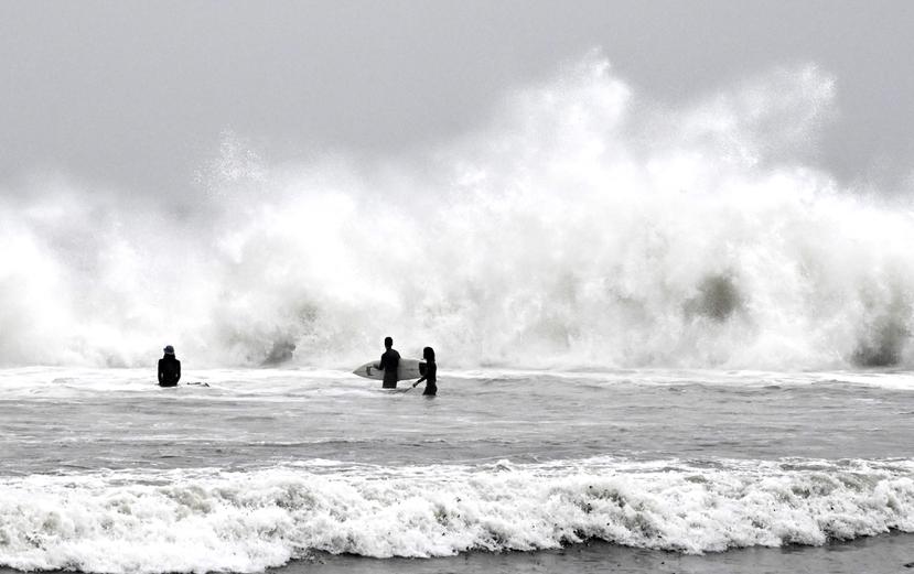 Surfistas aprovechan las olas durante una tormenta en Venice Beach, en Los Ángeles, el sábado 14 de enero de 2023.