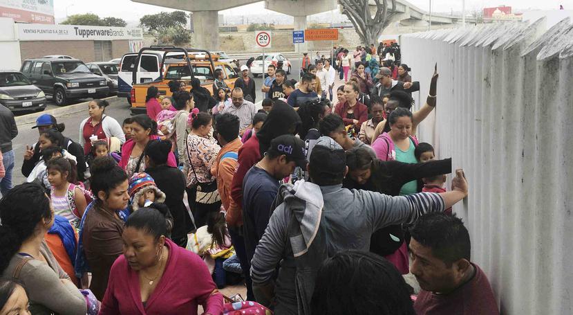 Decenas de personas que piden asilo político en EEUU hacen cola a la espera de ser entrevistados por las autoridades estadounidenses en Tijuana, México. (AP)