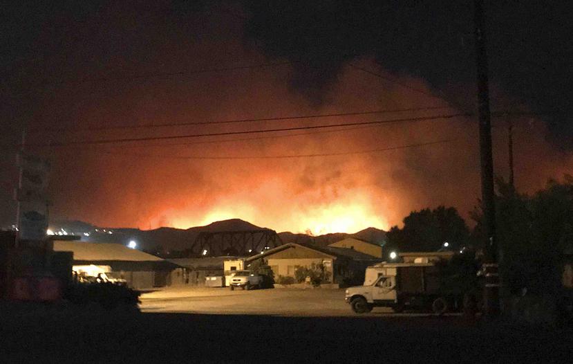 Al menos un bombero resultó herido en el esfuerzo por contener el fuego, que sigue propagándose y amenazando la localidad californiana, según el Departamento de Bomberos del condado de Ventura. (The Associated Press)