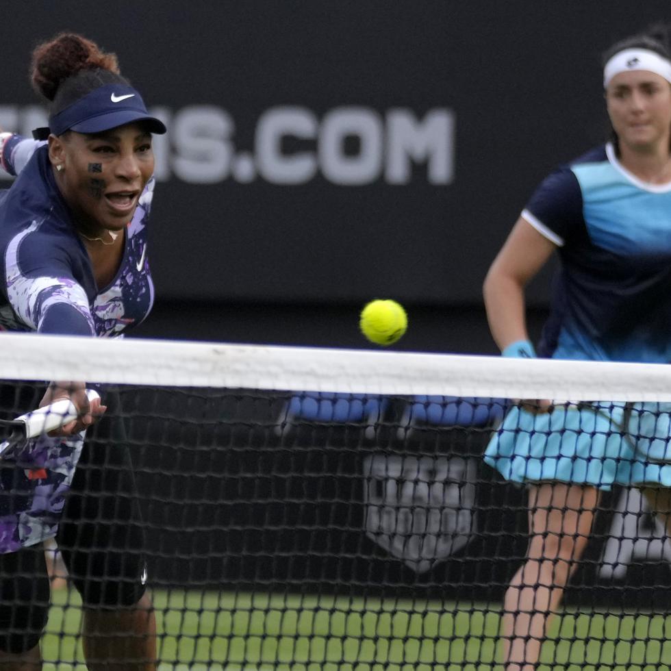 Serena Williams devuelve ante la mirada de Ons Jabeur durante un partido de dobles en el torneo de Eastbourne.