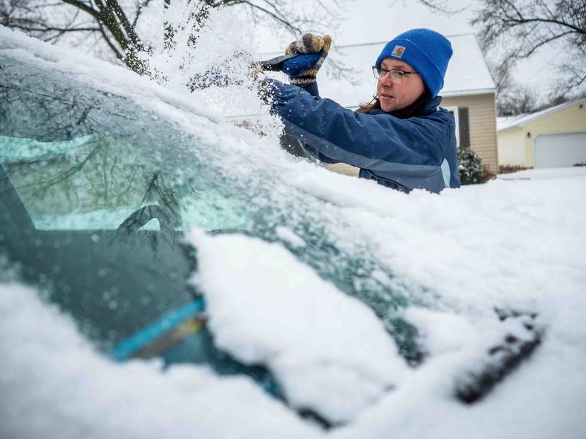 Colleen Streefland quita la nieve de su automóvil durante una nevada el sábado 14 de abril de 2018 en Rochester, Minnesota. (AP)