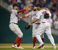 Xander Bogaerts, izquierda, Kyle Schwarber, centro y  Rafael Devers, celebran tras el triunfo el domingo de los Red Sox, que el martes reciben a los Yankees de Nueva York en el juego de eliminación.