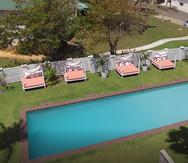 La nueva piscina de Villa Montaña Beach Resort está rodeada de grama y cabañas.