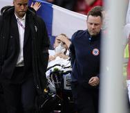 Paramédicos retiran en camilla al jugador danés Christian Eriksen, quien se desvaneció en un partido de la Eurocopa.