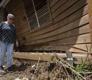 María Matos junto a su hogar destruido por un deslizamiento en Naranjito.